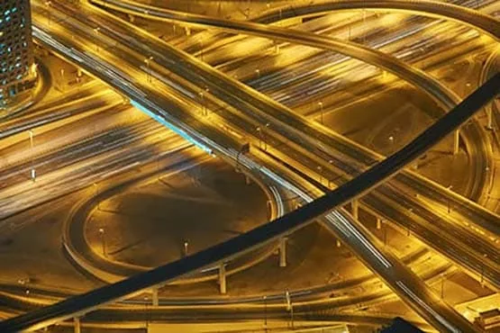 Échangeurs routiers éclairés la nuit, photographiés depuis le ciel.